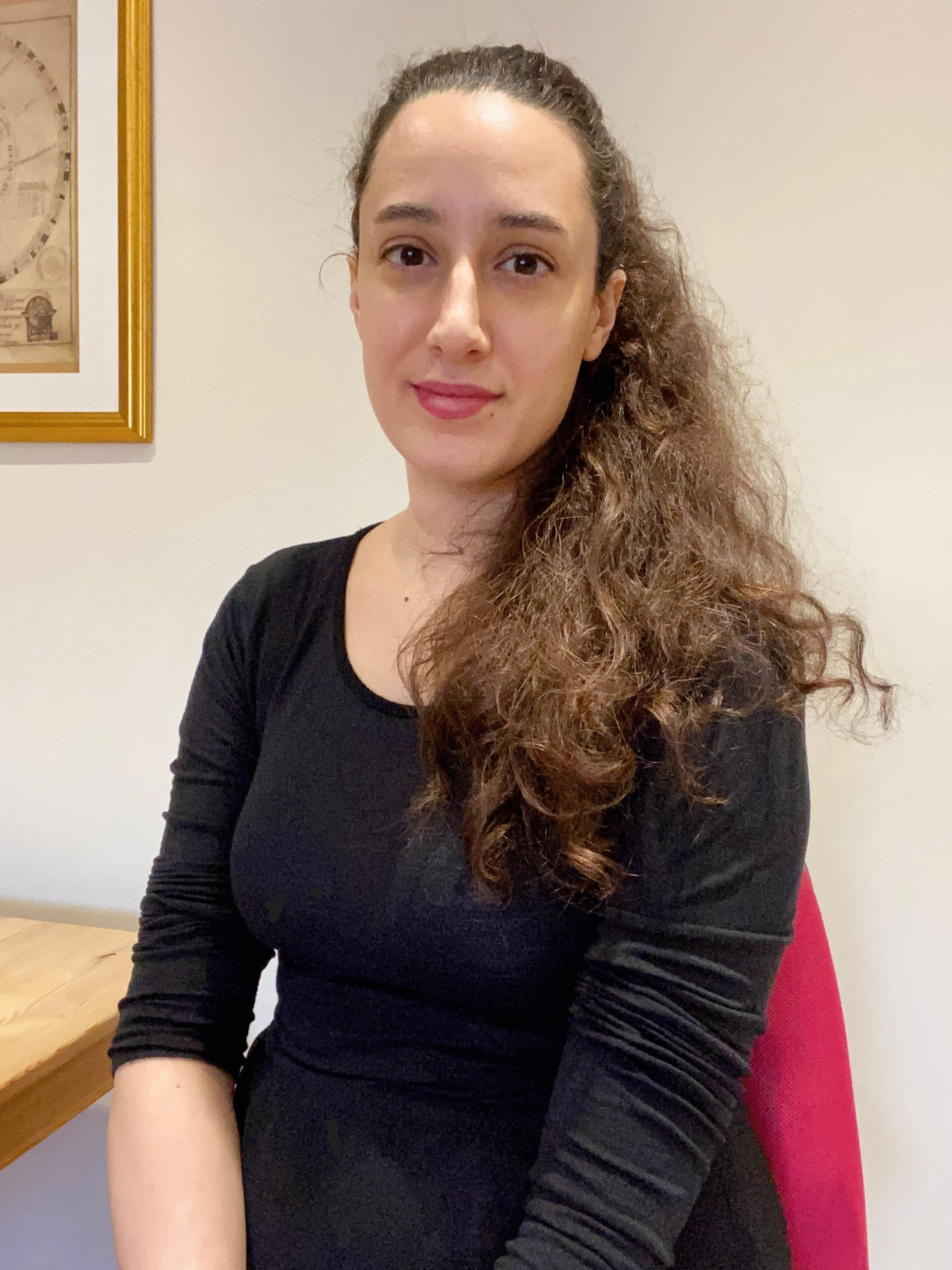 Diana Zannis author sitting at desk with birth chart poster in background